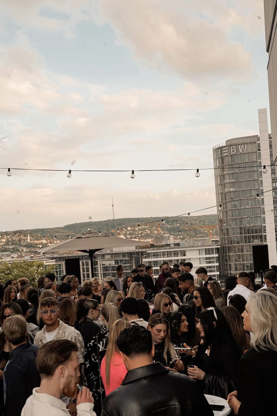 Gemischtes Publikum bei einer Rooftop-Party über Stuttgart